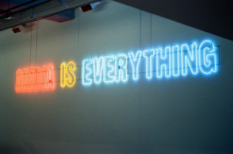 Neon sign on a wall reading 'HEAVEN IS EVERYTHING' in red, yellow, and blue lights.